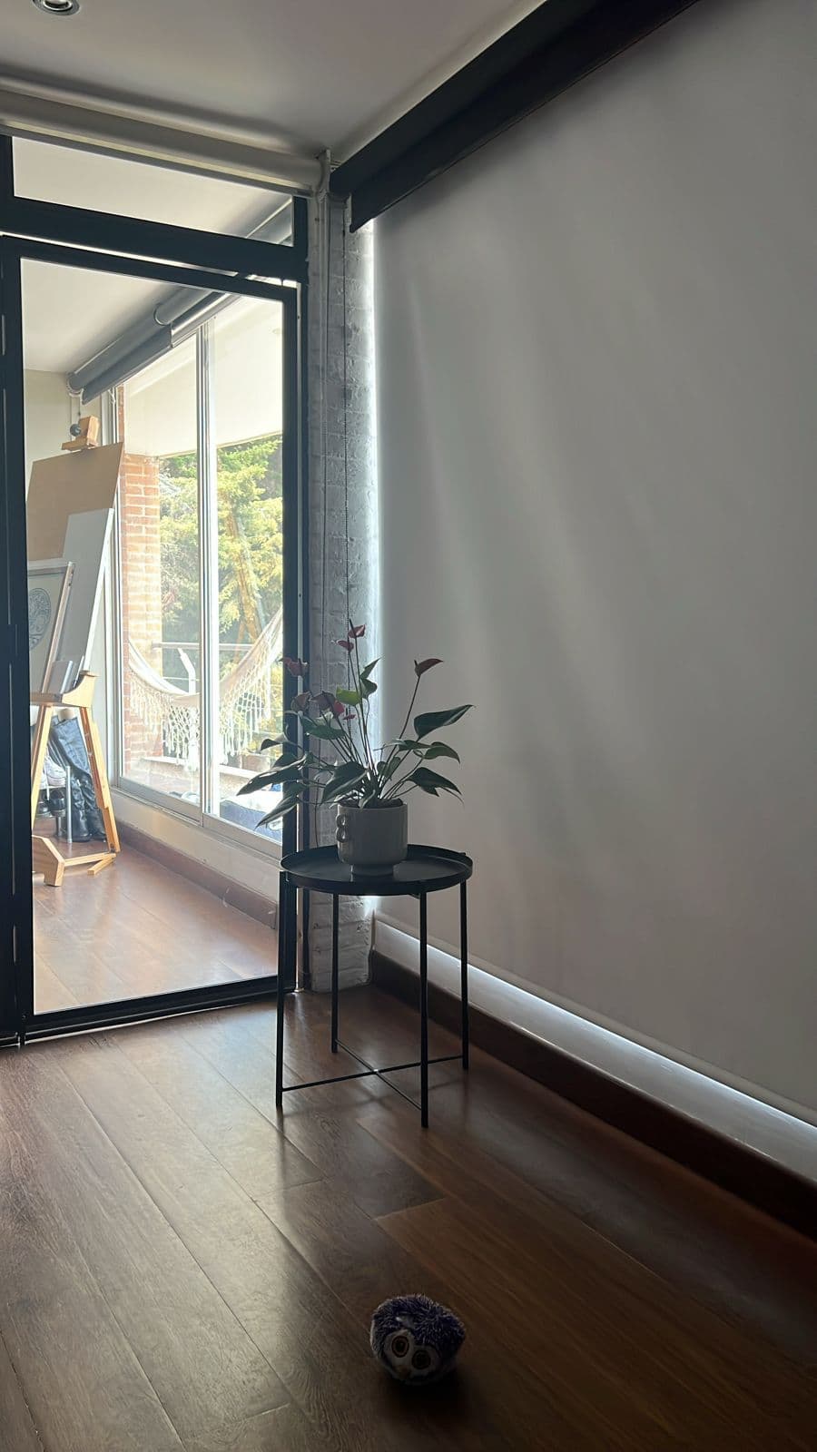 Cortina roller blanca semitransparente en pasillo con luz natural