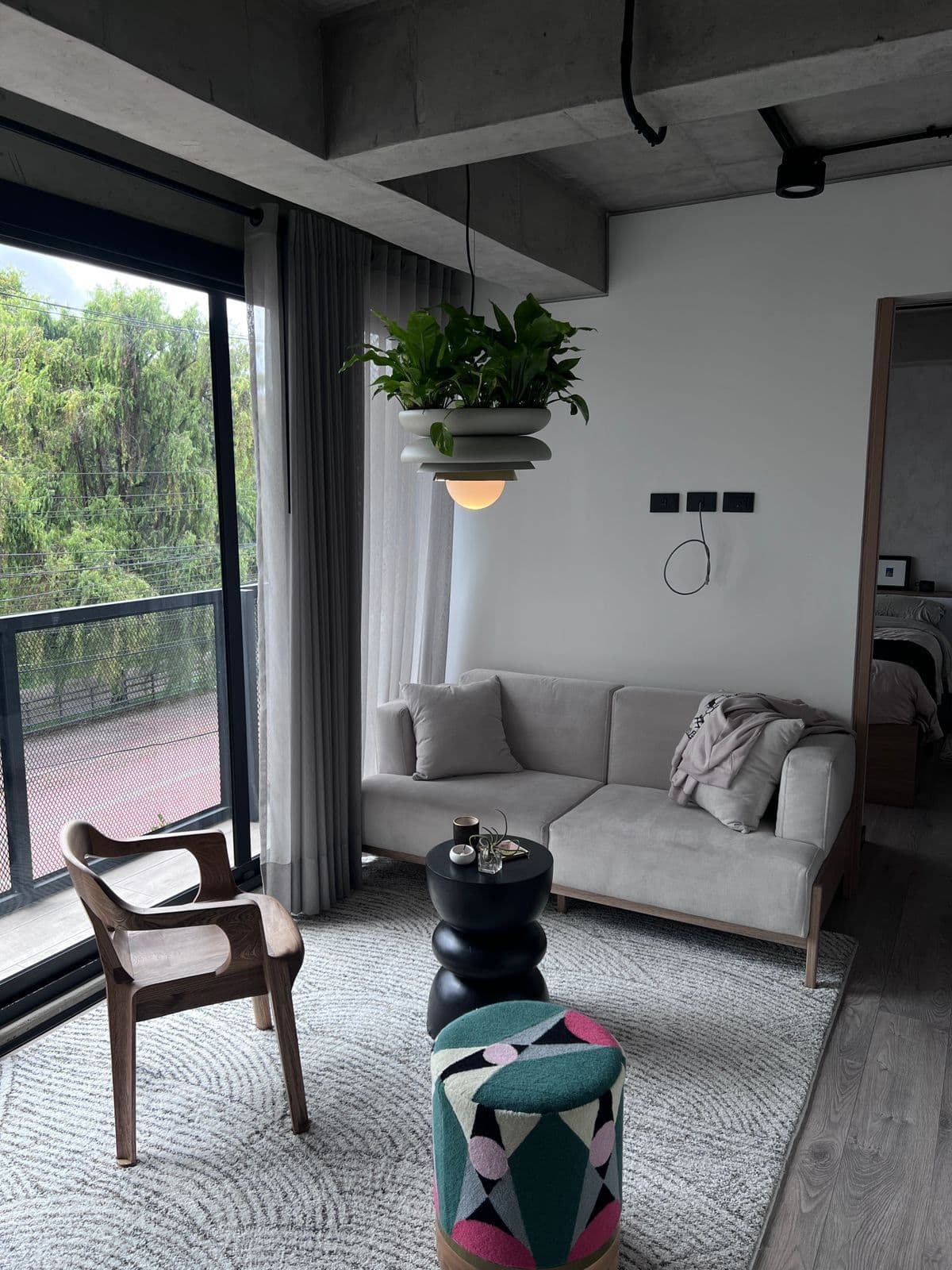 Cortinas de tela gris en sala moderna con concreto expuesto en Bogotá